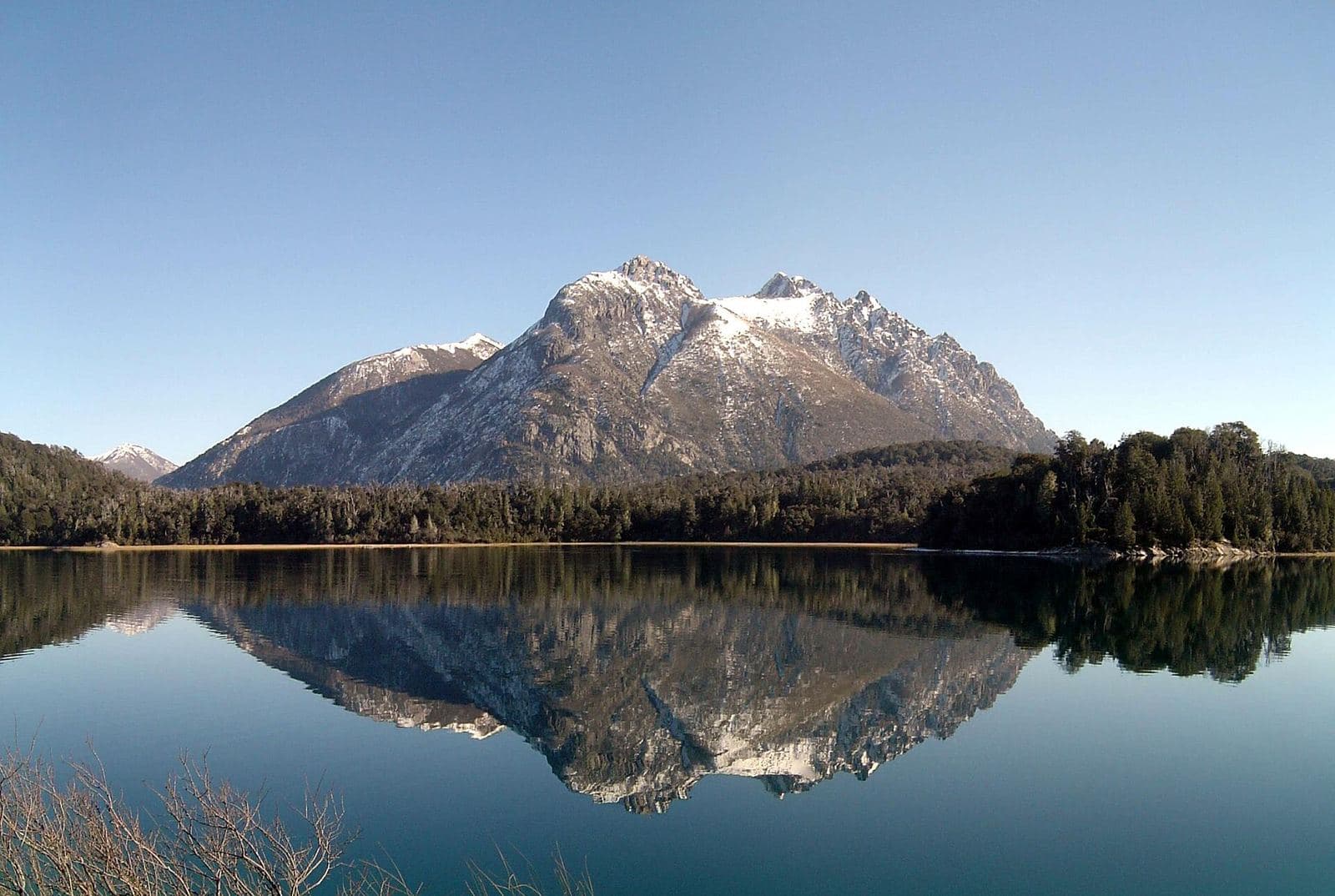 A snow-dusted peak mirrored in a calm lake on the Circuito Chico near Bariloche, Patagonia
